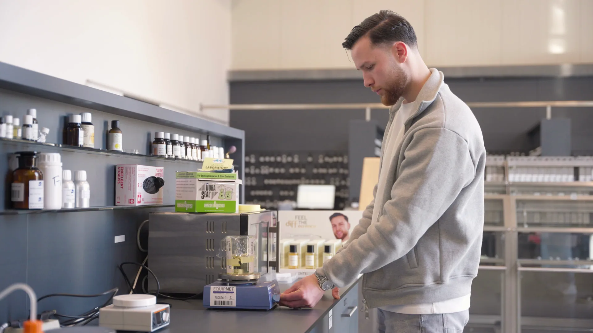 Mitarbeiter am Arbeitstisch mit Becherglas auf einer Waage in unserer Parfumproduktion in Norderstedt